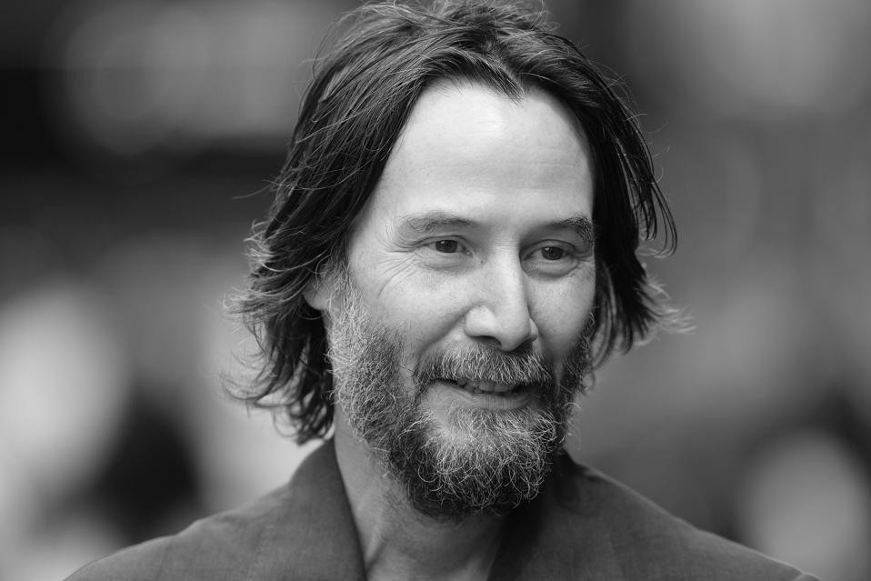 Black-and-white portrait of a man with long hair and a greying beard