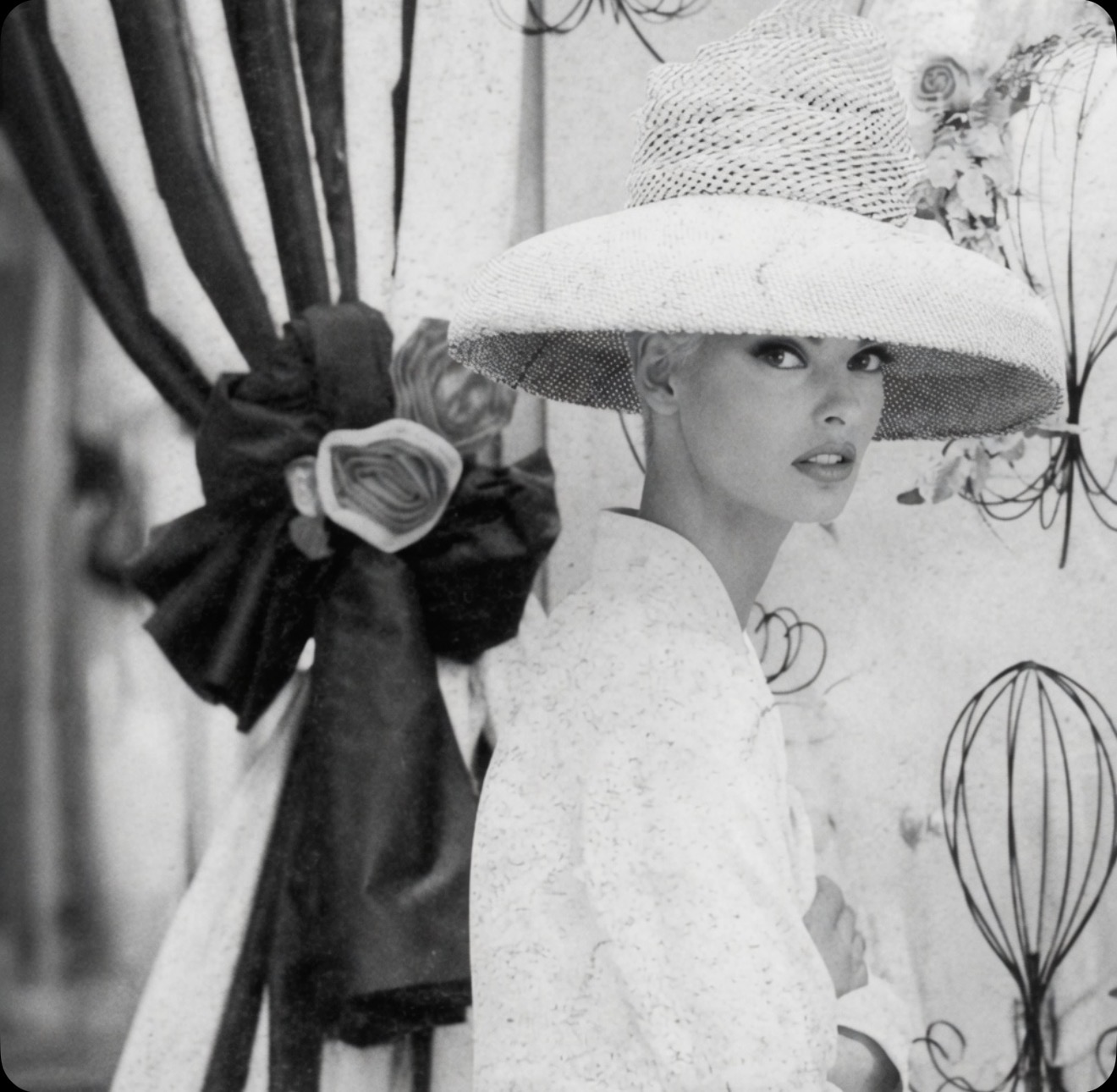 Black-and-white portrait of a woman in a wide-brimmed straw hat and white coat