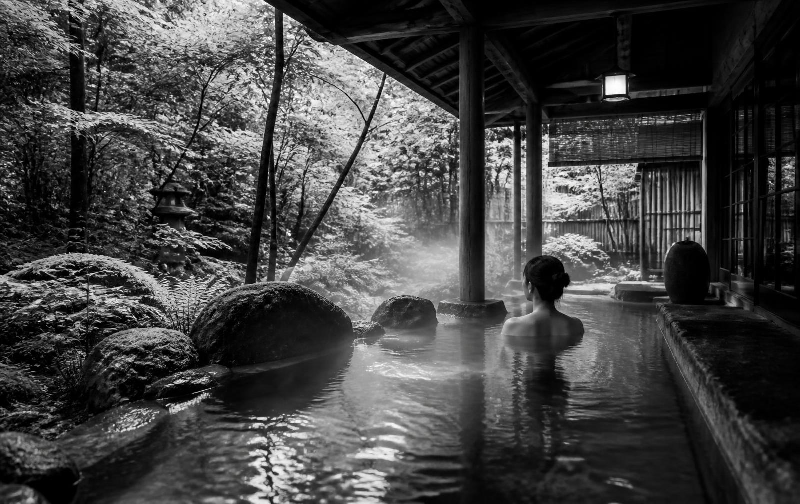 Black-and-white photograph of The Spa at Aman Kyoto, an outdoor onsen surrounded by forest