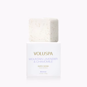 A white square box with a Voluspa Mountain Lavender & Chamomile Bath Soak on top.