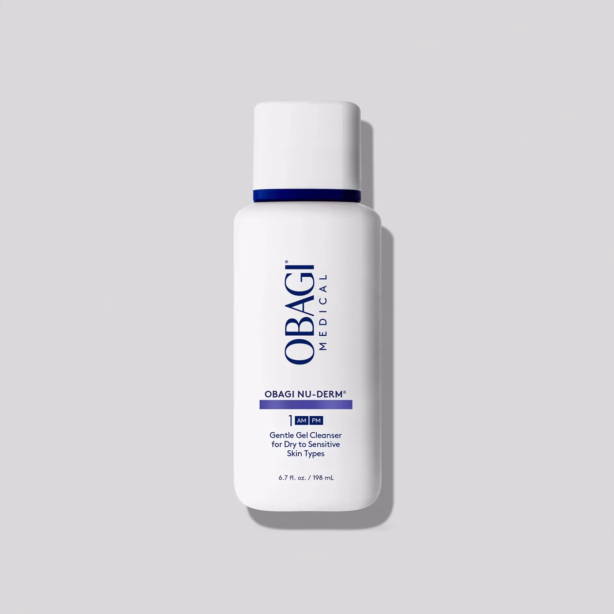 A white bottle of Obagi gentle cleanser, labeled in blue and black text for dry to sensitive skin, set against a light gray background.