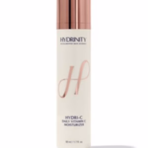 A white bottle of Hydrinity Hydri-C Vitamin C Moisturizer with a rose gold cap and logo stands upright against a white background.
