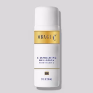A bottle of Obagi C-Day Exfoliating Lotion with a white and gold label, displaying the product name, stands upright against a light gray background.