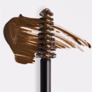 A close-up of the Revitalash Brow Gel in Soft Brown shows its wand with creamy brown gel smeared on a white background, highlighting the brush bristles and rich texture.