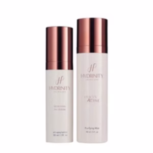 The Hydrinity Age Renewal Kit features two white bottles with rose gold caps—a smaller Renewing HA Serum and a larger Purifying Mist—both showcasing a clean, minimal design.