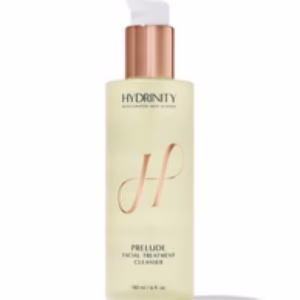 A bottle of Hydrinity prelude cleanser with a gold pump and label, featuring a large stylized H and product details on a light background.