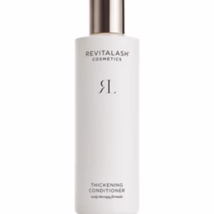 A white bottle of Revitalash conditioner with a silver cap, displaying minimalist black text and logo on the front.